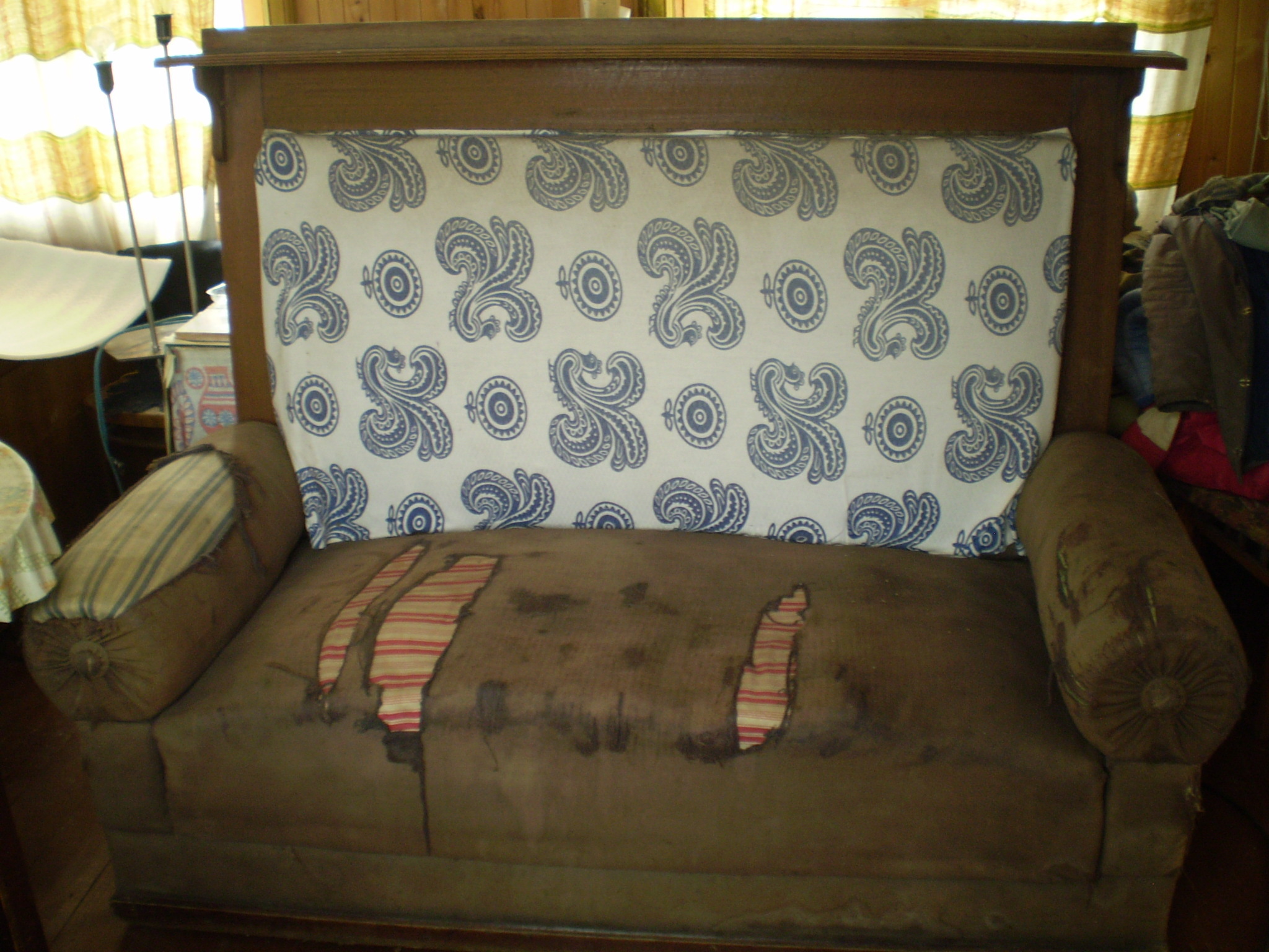 Реставрация старого дивана с валиками и высокой спинкой